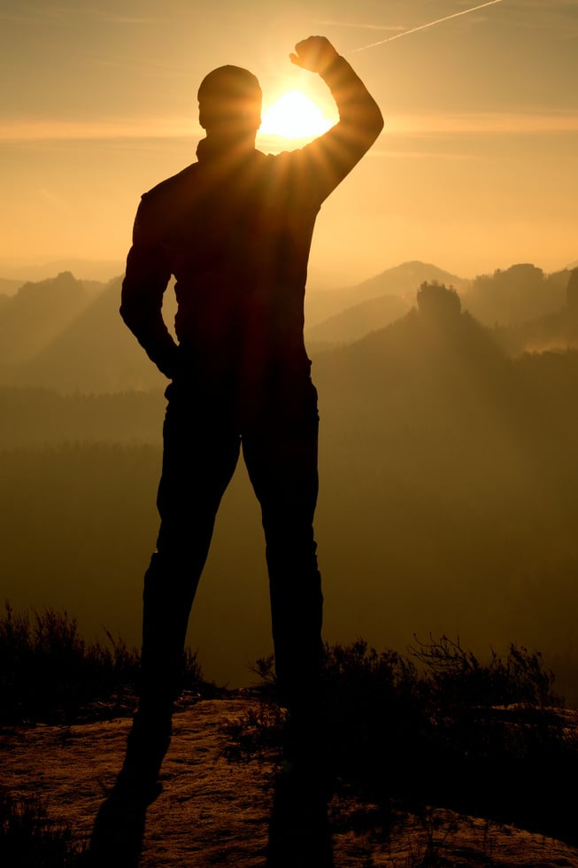 Self confident man on rock watching fogy landscape